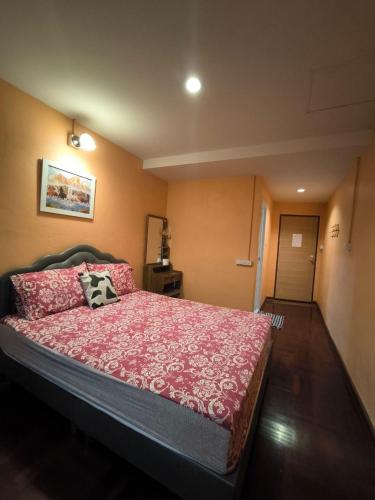 a bedroom with a large bed with a red bedspread at Santo house Bangkok in Bangkok