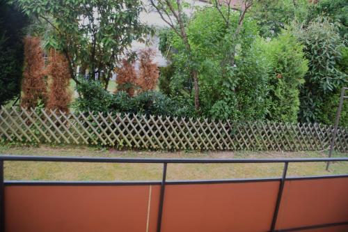 a fence in front of a yard with trees and bushes at GraceHomes - Garage, Ventilator, Free Coffee, Airport, Messe, Stuttgart, WiFi up to 6 Guests in Leinfelden-Echterdingen