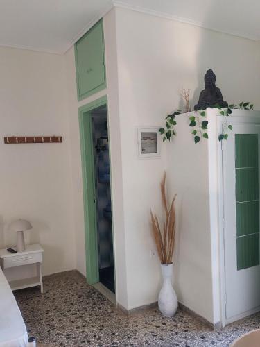 a room with a green door and a vase at Vitamin sea Studio in Panayía