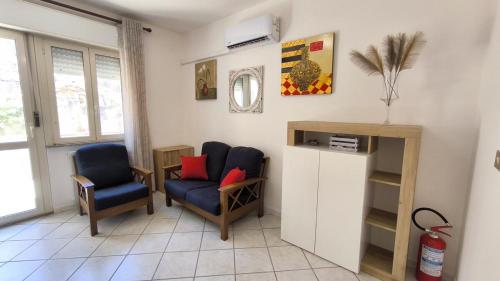 a living room with two chairs and a table at Il Fortino Residence - Three-room apartment La Maddalena in La Maddalena