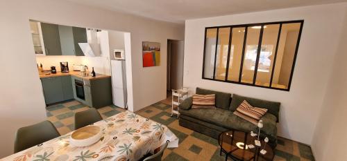 un salon avec un canapé et une table dans l'établissement Frisch renovierte klimatisierte Ferienwohnung - nur 100 m vom Strand entfernt, à Portiragnes