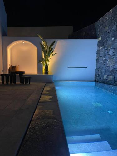 a house with a swimming pool at night at Koniko Santorini Private Pool Villas in Santorini