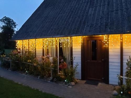 a house with christmas lights on the side of it at AlongtheWay E77 in Ieriķi