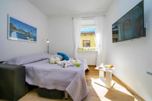a bedroom with a bed and a table with flowers on it at Nido sui Tetti di Riva del Garda - Happy Rentals in Riva del Garda