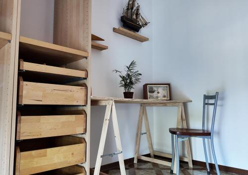 a table and a stool next to a wall at Da Jack Rooms, la tua casa vacanze! in Penne