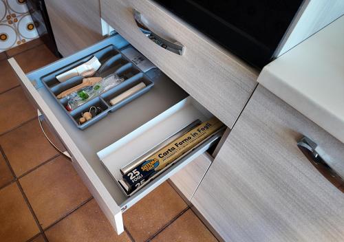 an open drawer in a kitchen cabinet with at Da Jack Rooms, la tua casa vacanze! in Penne