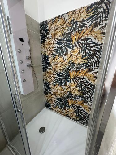 a shower stall with a patterned wall at Casa Camurria in Aci Castello