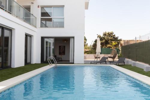 a swimming pool in the backyard of a house at Descubre Villa Oasis - Confort, diseño y naturaleza a un paso de Valencia in Chiva