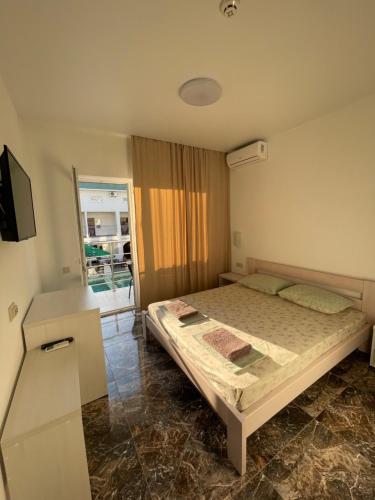 a bedroom with a bed and a tv and a window at OSTRIV Hotel in Zatoka