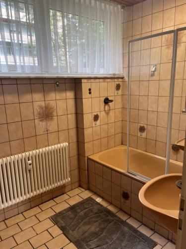 a bathroom with a tub and a sink at Stay 15 Kassel in Kassel