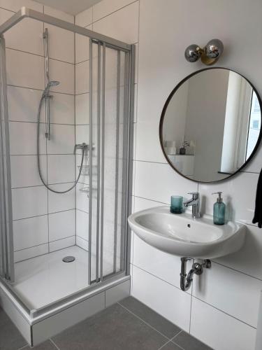 a bathroom with a shower and a sink and a mirror at Indigo Apartment in Kassel