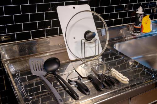 a kitchen sink with utensils in a dish rack at KAME Inn Osaka in Osaka