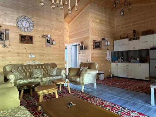 a living room with couches and a clock on the wall at Villa E&E Dragancë in Gjilan