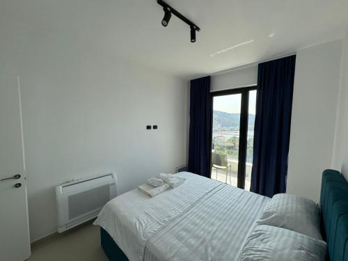 a bedroom with a bed and a large window at Driton`s Apartments in Shëngjin