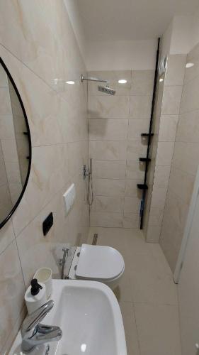 a bathroom with a sink and a toilet and a mirror at Driton`s Apartments in Shëngjin