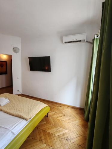 a room with a bed and a tv on the wall at Central 2 Budget Accomodation in Bucharest