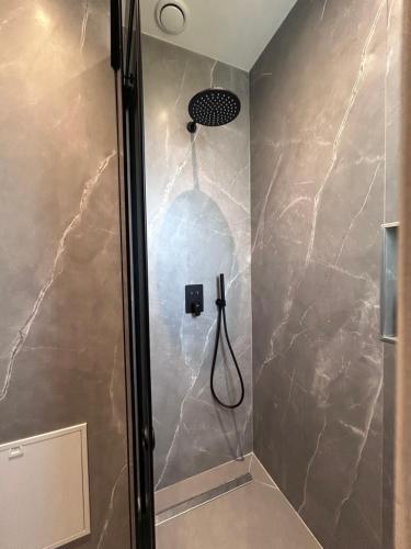 a shower with a shower head in a bathroom at Escape Suites in Dhërmi