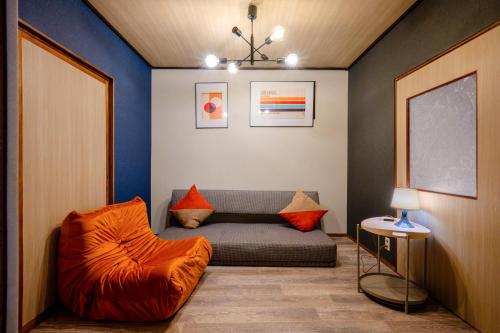 a living room with a couch and a chair at KAME Inn Osaka in Osaka