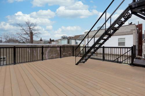 a wooden deck with a black railing and a staircase at New Luxury Suite Heart of Toronto Sleeps 10 in Toronto