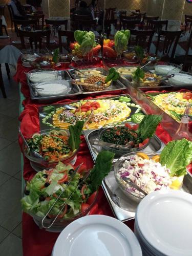 a buffet line with many different types of pizzas and salads at Al Jazeera Royal Hotel in Abu Dhabi