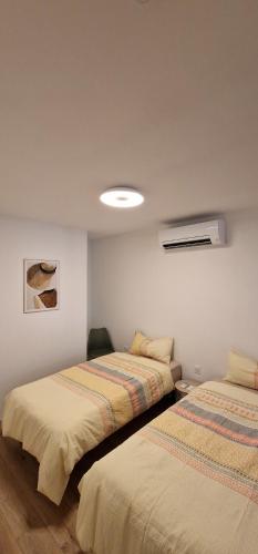 deux lits côte à côte dans une pièce dans l'établissement Frisch renovierte klimatisierte Ferienwohnung - nur 100 m vom Strand entfernt, à Portiragnes