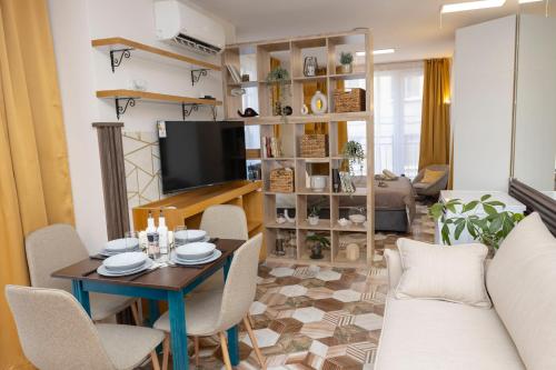 a living room with a table and chairs and a television at Good Mood Apartments & Parking in Plovdiv