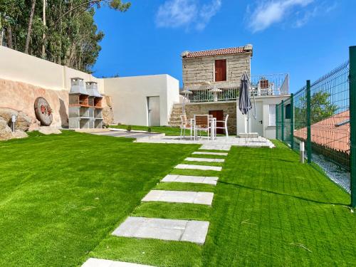 a backyard with a grass yard and a house at Casa das Laixas in Laxe