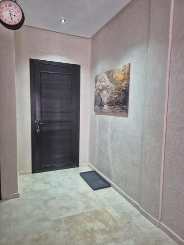 a hallway with a door and a clock on a wall at Villa-l-arganier - Piscine - Sans vis-à-vis in Eddir