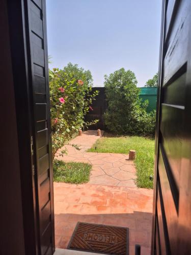 an open door to a garden with a brick walkway at Villa-l-arganier - Piscine - Sans vis-à-vis in Eddir