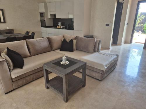 a living room with a couch and a table at Villa-l-arganier - Piscine - Sans vis-à-vis in Eddir