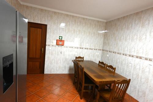 a dining room with a wooden table and chairs at ComportAMar in Comporta