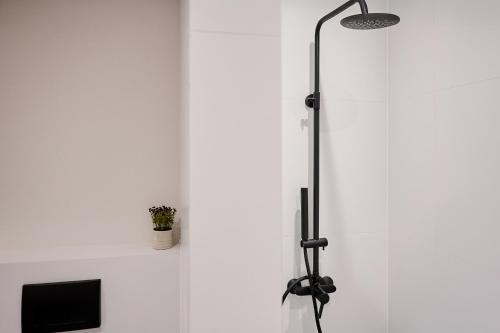 a floor lamp in a room with a white wall at Reve Suites Ioannina in Ioannina
