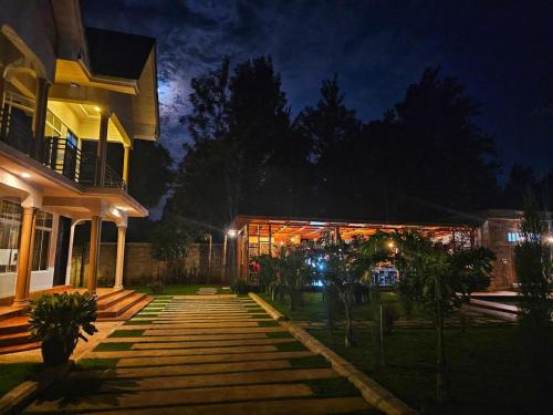 a house at night with a building with lights at Nguchiro Palace Hotel in Moshi