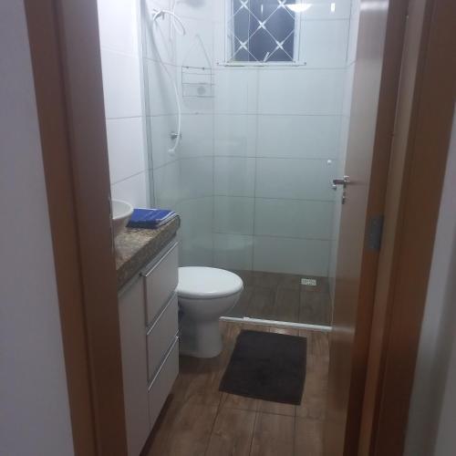 a bathroom with a toilet and a shower and a sink at Apt confortável in Camboriú