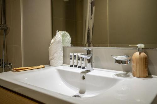 a bathroom sink with a soap dispenser and a mirror at Quickstay holiday homes1BHK Retreat Peaceful & Bright in Dubai