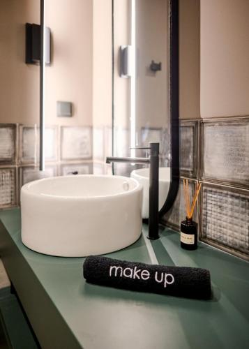 a bathroom with a sink and a sign that says make up at Reve Suites Ioannina in Ioannina