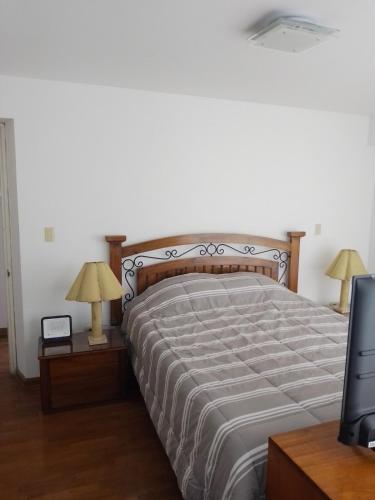 a bedroom with a bed with two lamps and a television at Miraflores, Lima, apartamento 2 dormitorios in Lima