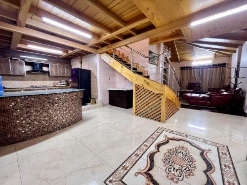 a kitchen with a staircase and a living room at Sunny Horizon - The Valley View Penthouse in Murree