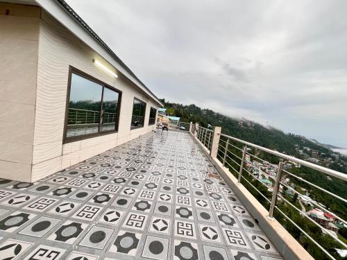 a balcony of a building with a person sitting on it at Sunny Horizon - The Valley View Penthouse in Murree