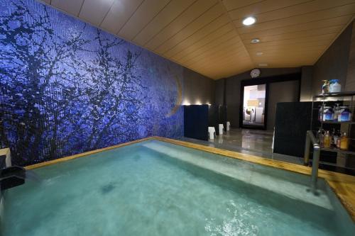 a swimming pool in a room with a blue wall at Almont Hotel Sendai in Sendai