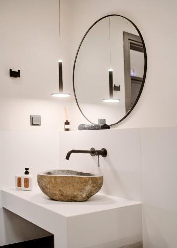 a bathroom with a stone sink and a mirror at Reve Suites Ioannina in Ioannina