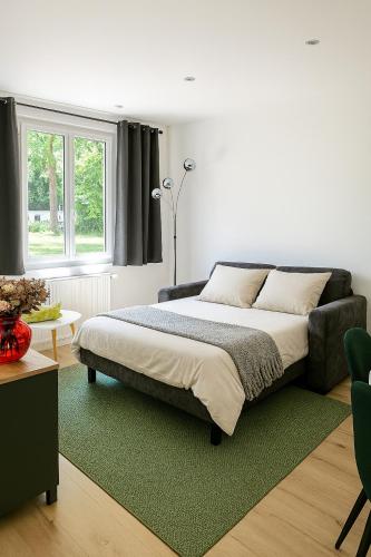 une chambre avec un lit et un tapis vert dans l'établissement Maison Mayel - Havre de Paix Chic & Nature à 30 min de Paris, à Lamorlaye