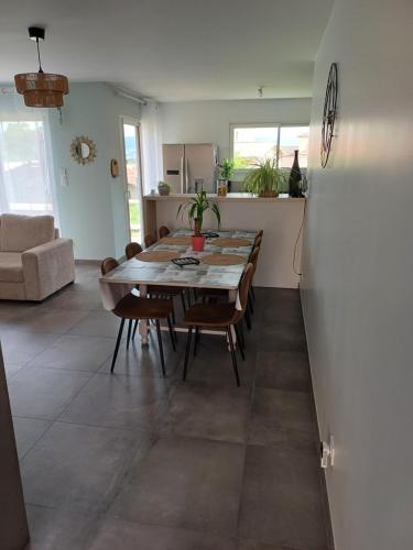 a dining room and kitchen with a table and chairs at Au cœur des pierres dorées in Bully
