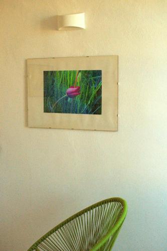 a picture hanging on a wall with a green chair at BB Dadaumpa in Novi Ligure