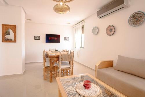 a living room with a table and a couch at 6-person appartment, terrace and spa in Marrakech