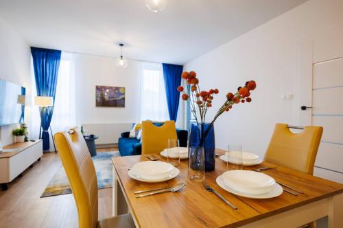 a dining room with a wooden table and yellow chairs at Onyx Oasis Residence- City Centre, Free Parking by StayNest in Rzeszów