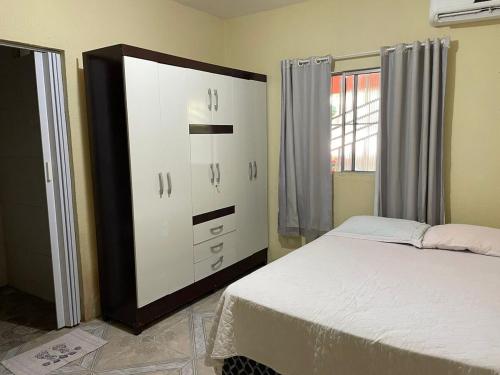 a bedroom with a white dresser and a bed at Recanto do Lima in Camocim