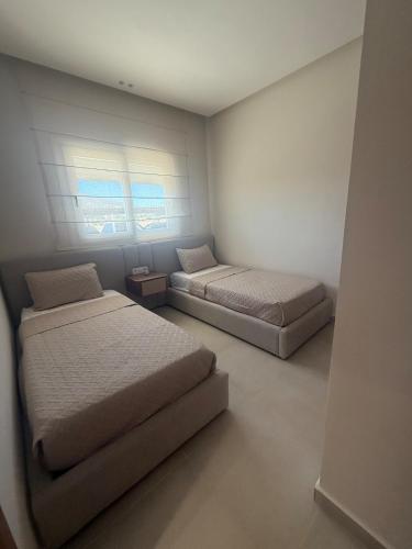 a bedroom with two beds and a window at Aqua Vista Retreat in Cabo Negro