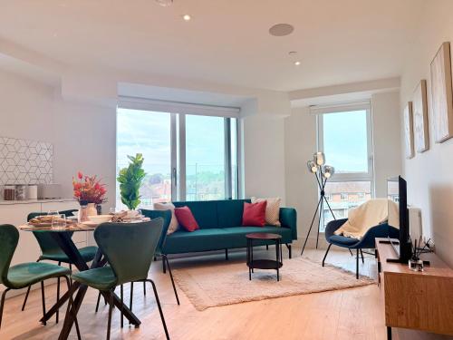 a living room with a blue couch and a table at Luxury 2bed With Gym Cinema & Games Room in New Malden