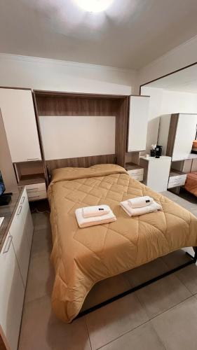 a bedroom with a bed with two towels on it at Studio Arena y Sol - MDQ Centro in Mar del Plata